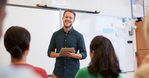 Educator standing at board presenting to other educators