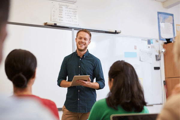 Educator standing at board presenting to other educators