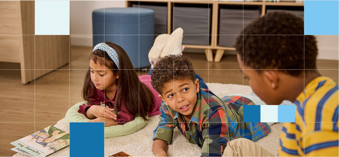Three school children on a rug in a classroom Three school children on a rug in a classroom